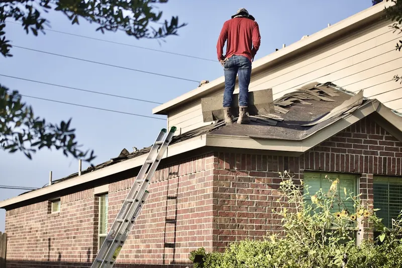 Professional roofer working on a residential roof in Bit-O-Home Trailer Park